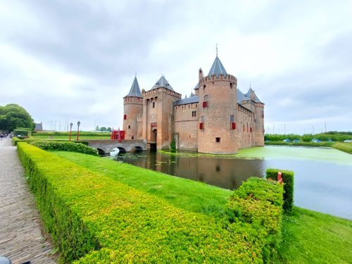 Free Historic Muiden Castle with towers and moat on a cloudy summer day. Stock Photo