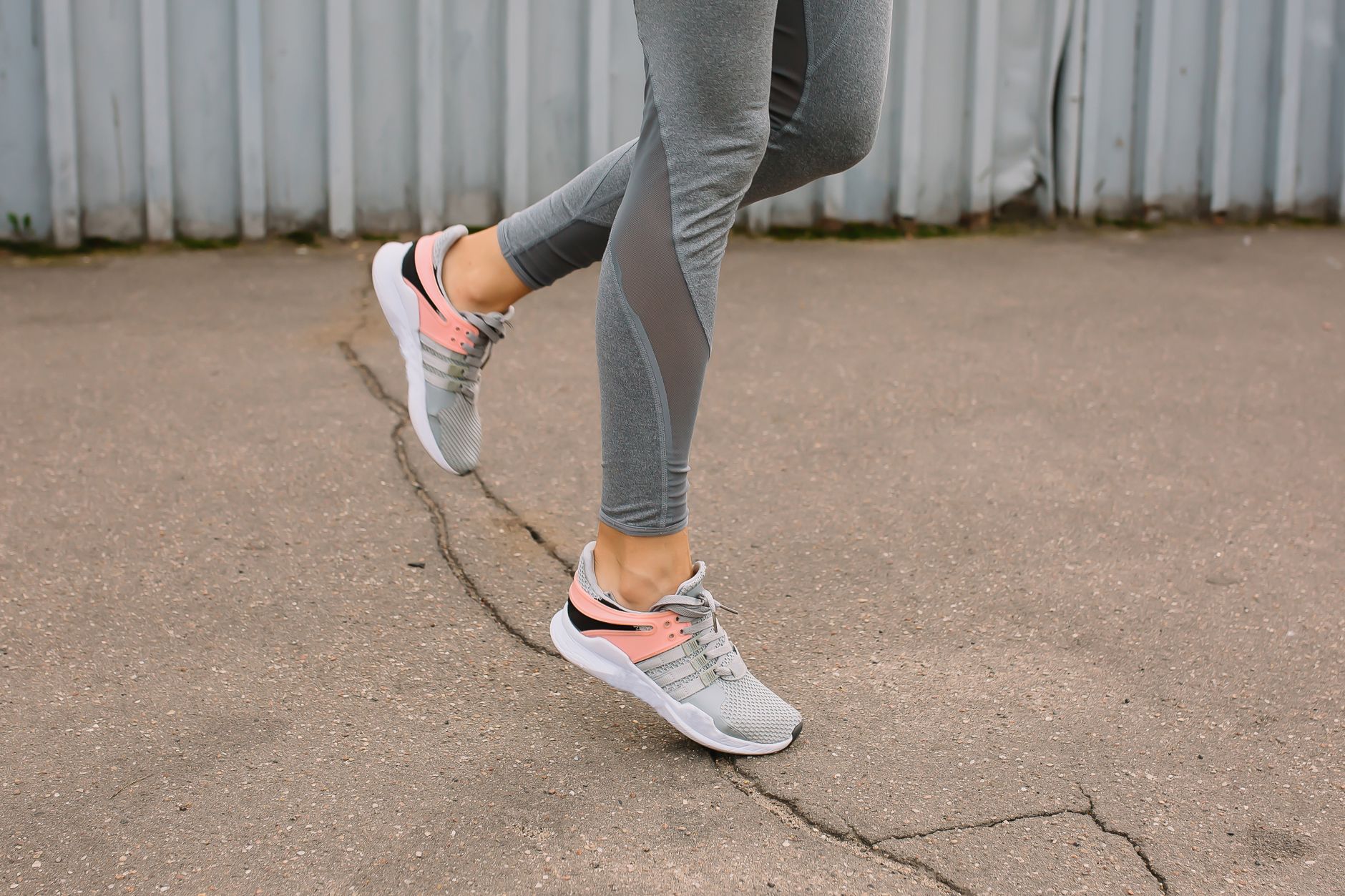 diosmin hesperidin for varicose veins after covid — Close-up of a woman running on pavement in gray leggings and sneakers.