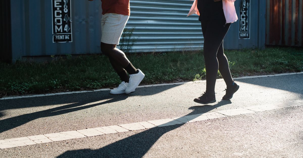 Two people jogging outdoors on a sunny day, emphasizing fitness and healthy lifestyle.