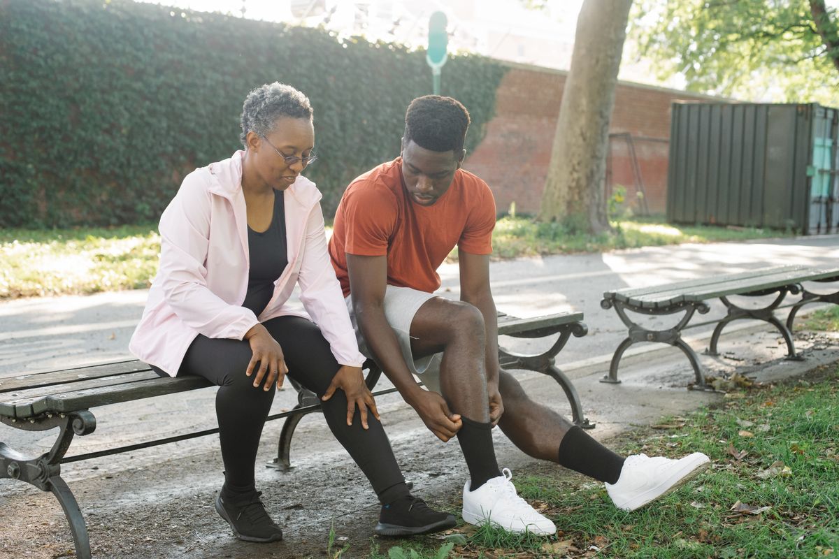 Woman sitting on a bench pulling up her compression socks