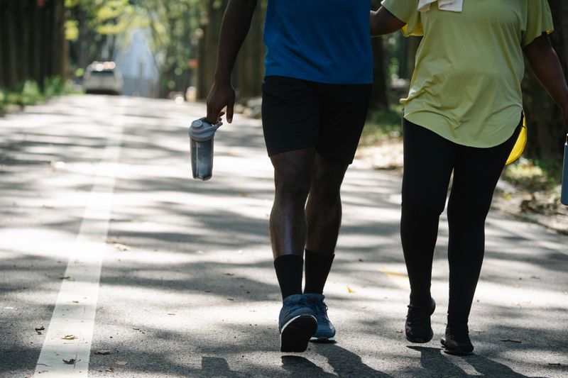 person carrying a small bag of groceries while walking back to office