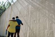 Back View Shot of People Walking Arm in Arm