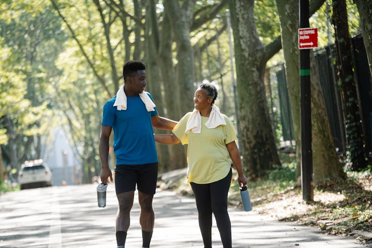 Young Man And Senior Woman Coming Back From Jogging In City