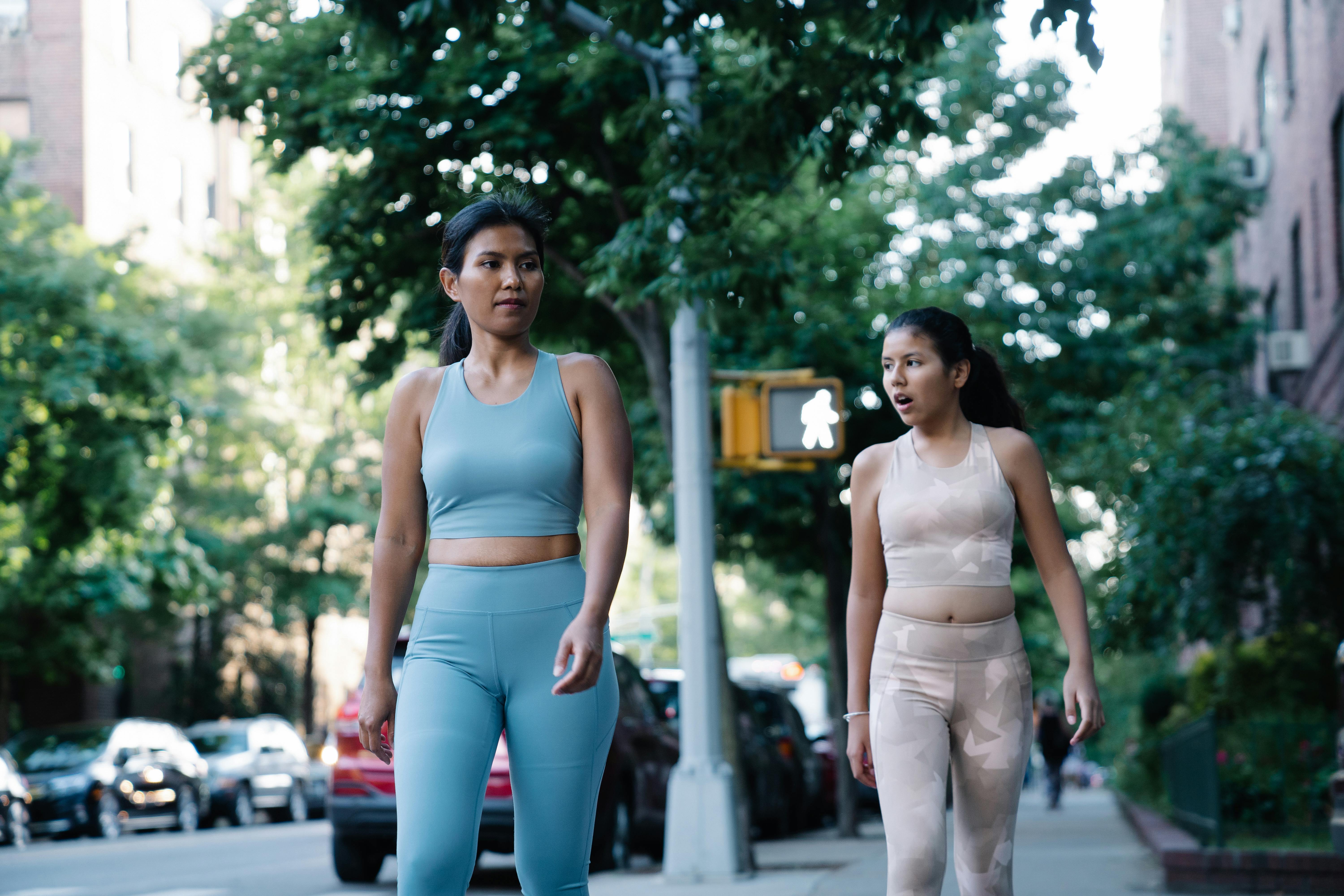 woman and teenage girl walking together down city street