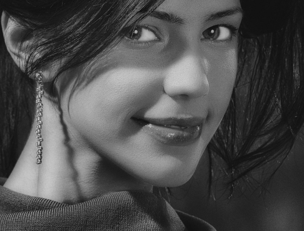 captivating black and white portrait of a smiling woman wearing earrin