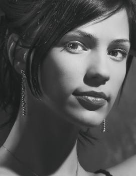 Close-up grayscale portrait of a woman with earrings, exuding elegance and beauty.