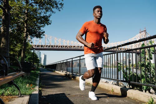 Man in Orange Crew Neck T Shirt Running