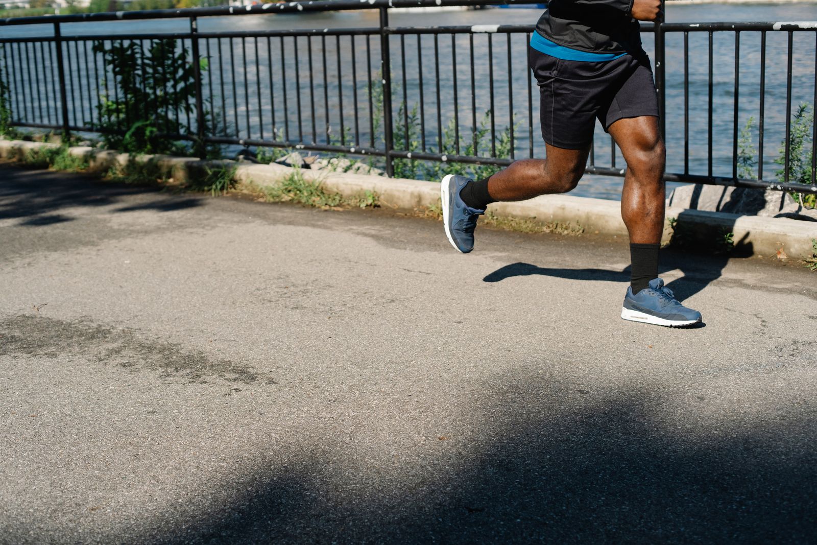 Runner on a sunny path wearing fitted running gear with knees visible