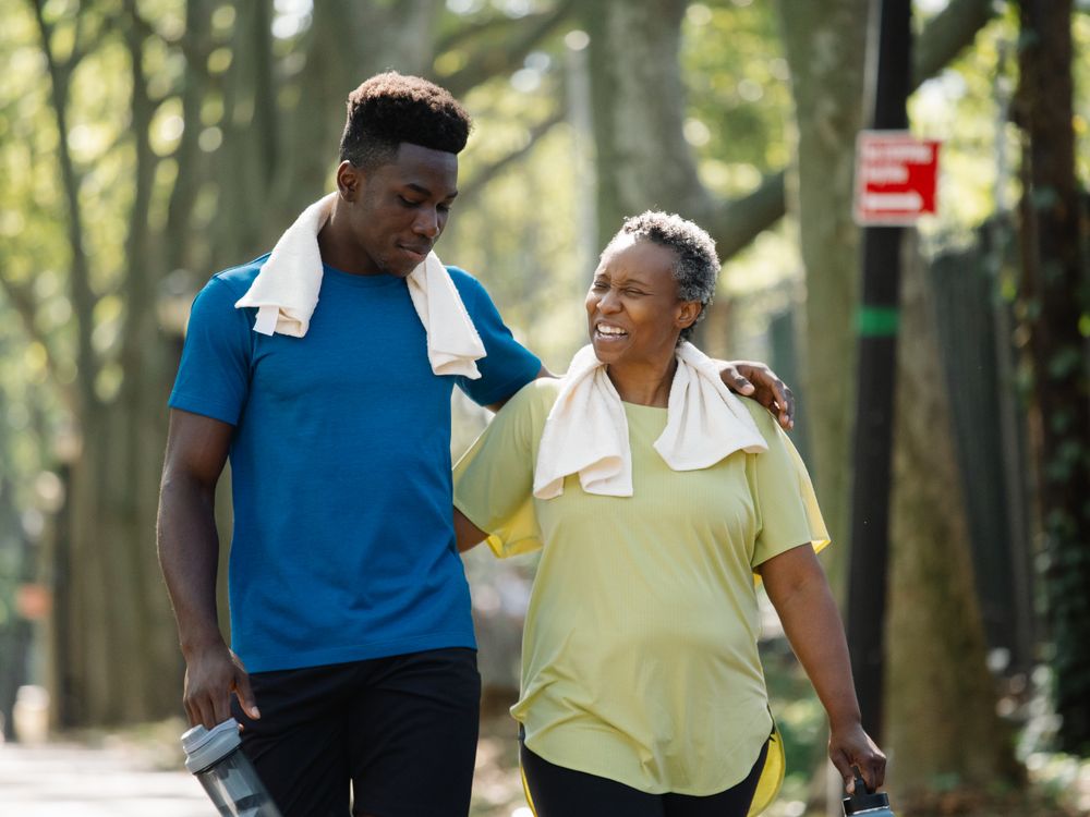 Elderly woman and young man walking in a park