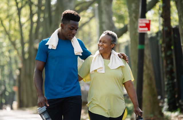 Elderly woman and young man walking in a park