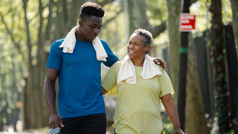 Elderly woman and young man walking in a park