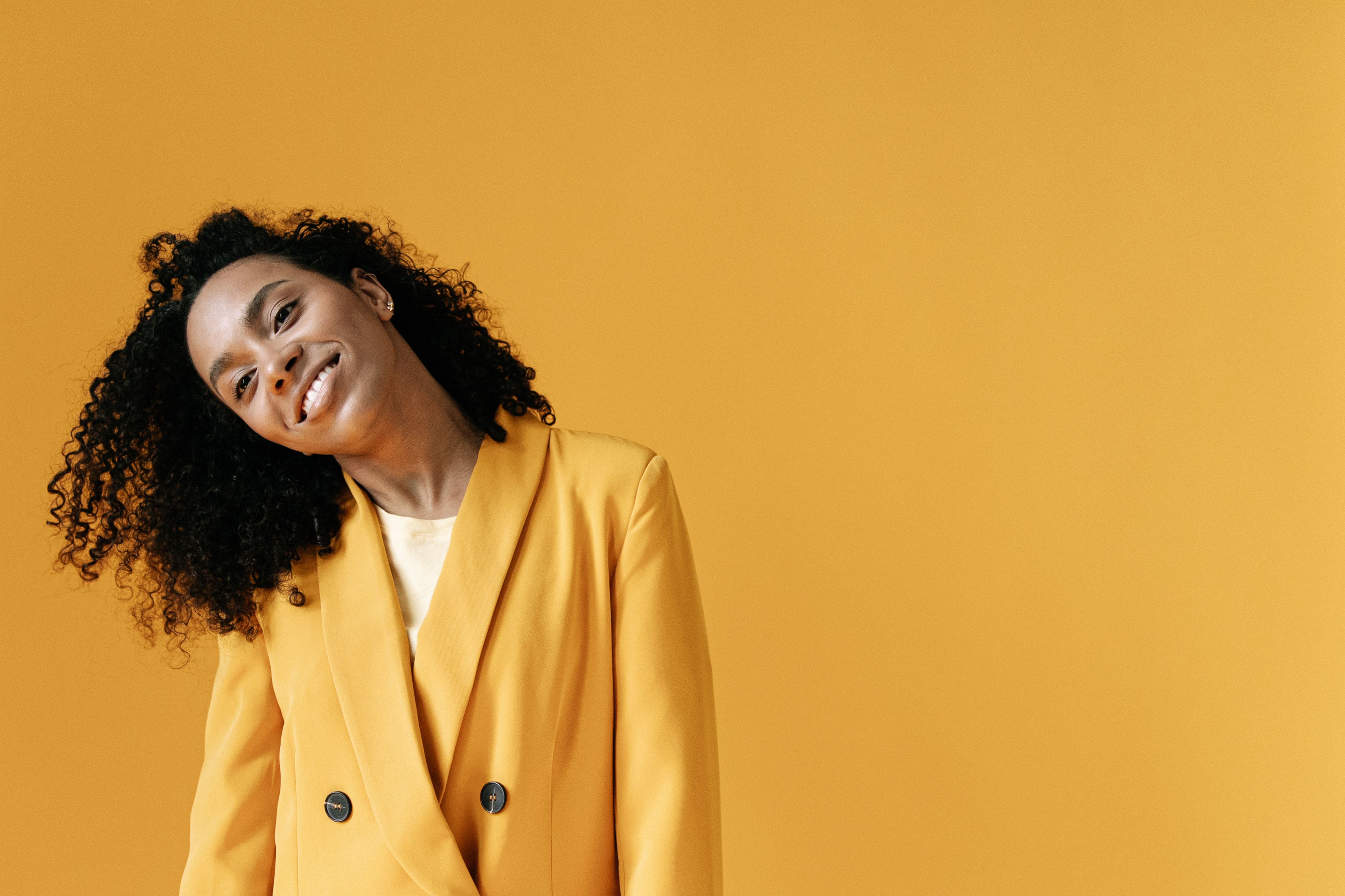 Woman in Yellow Blazer Standing on Yellow Background · Free Stock Photo