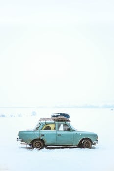 吉尔吉斯斯坦的雪地里停着一辆老爷车，捕捉到宁静的冬季风景