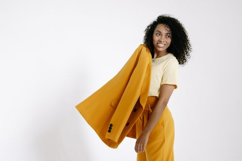 Free Confident woman posing in yellow outfit with a modern style. Stock Photo