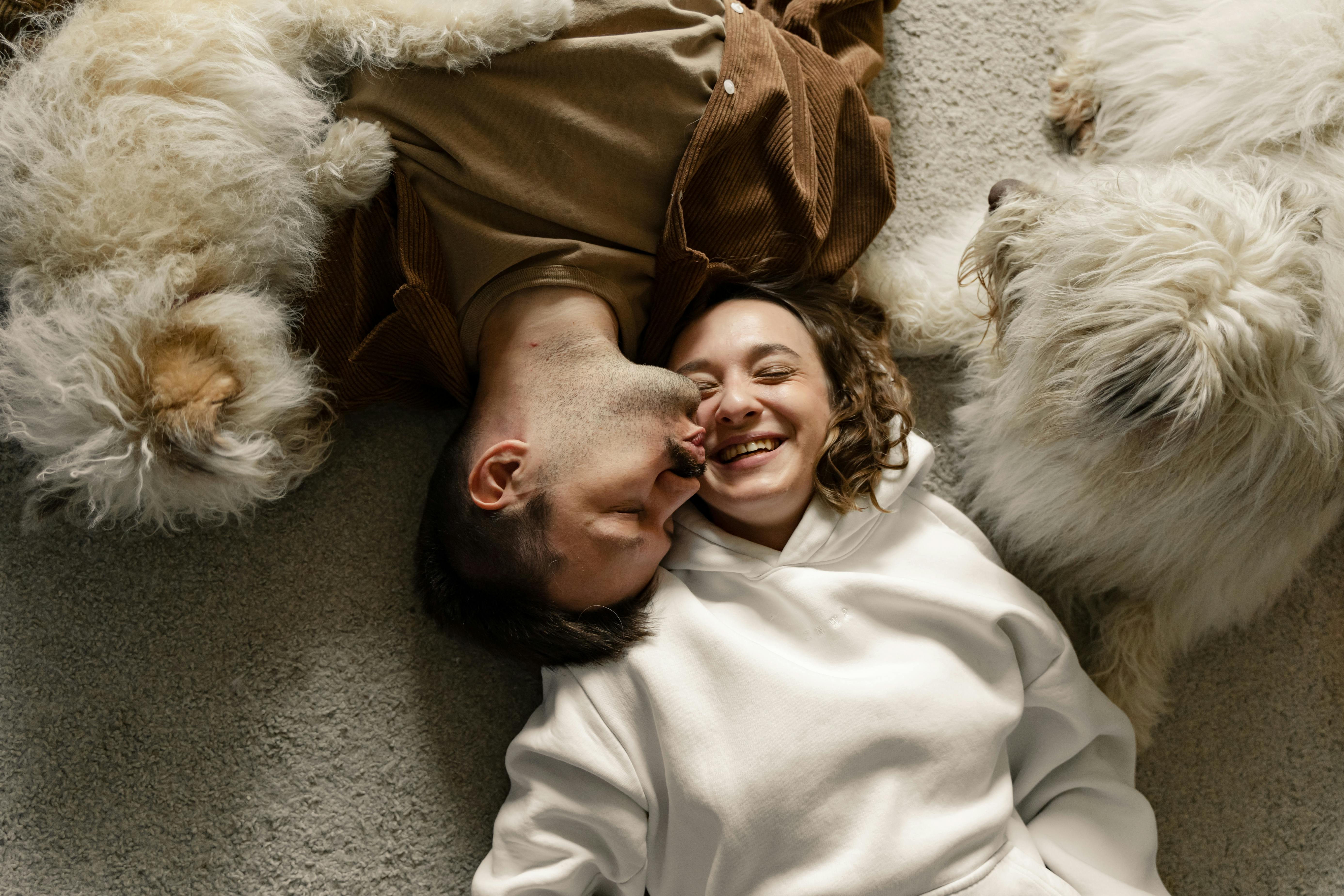 couple lying on the carpet with their dogs