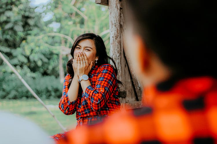 Woman Red Plaid Long Sleeves Covering Her Mouth While Laughing