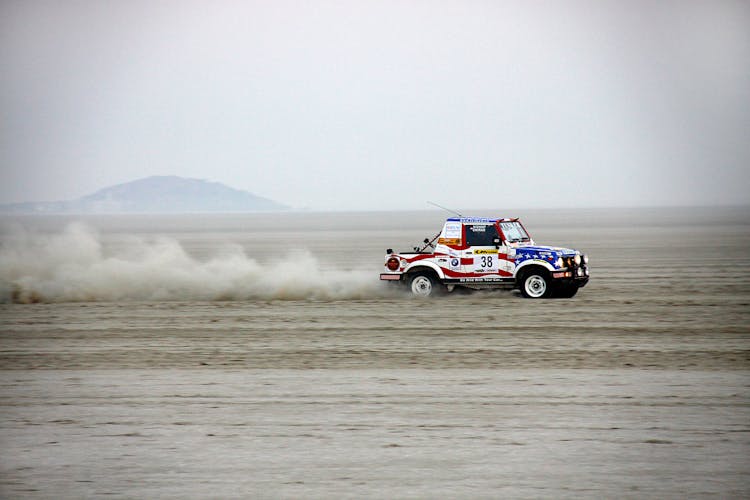 A Car Driving Fast On A Desert