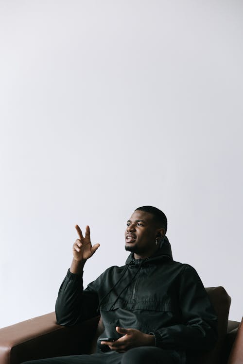 Man in Black Couch Sitting on a Couch