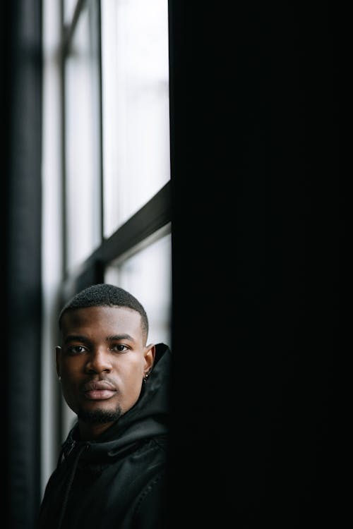 A Man Standing Near a Glass Window