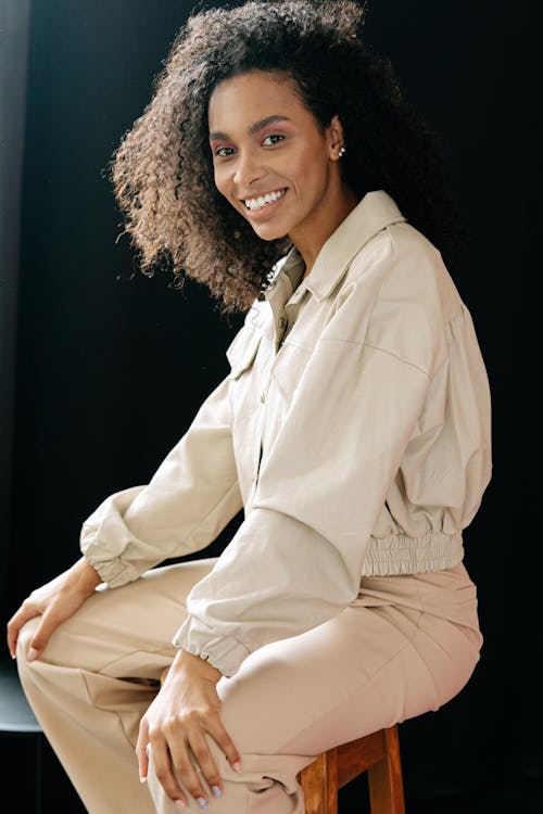 Woman with Brown Curly Hair, Posing on a Chair