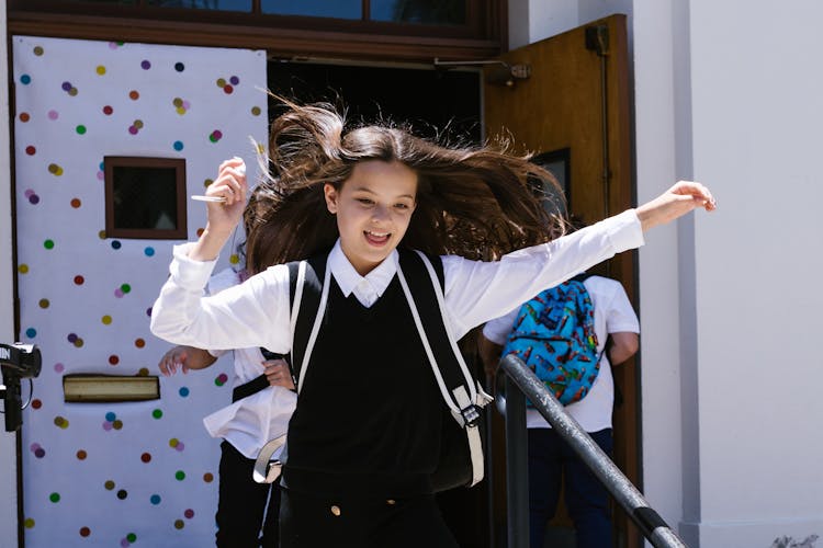 A Happy Girl Running While Wearing Her School Uniform 