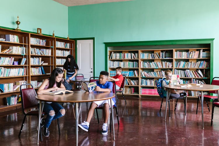 Kids Reading Books In The Library 