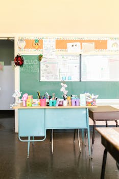 Inviting classroom with a green chalkboard, desks, and colorful school supplies.
