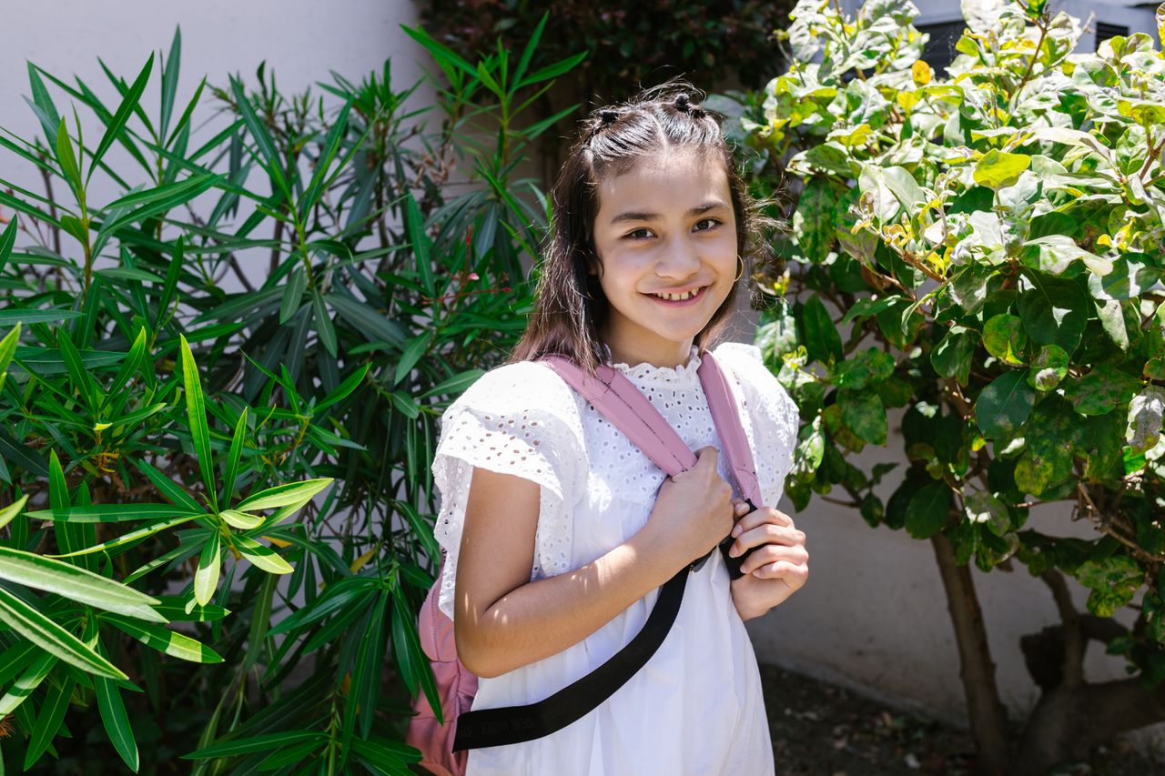 Smiling girl with a backpack outdoors
