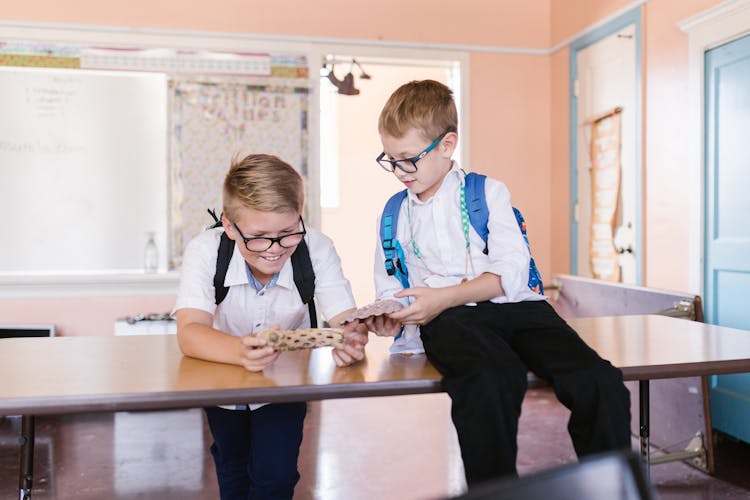 Boys In School Uniform Looking On A School Project