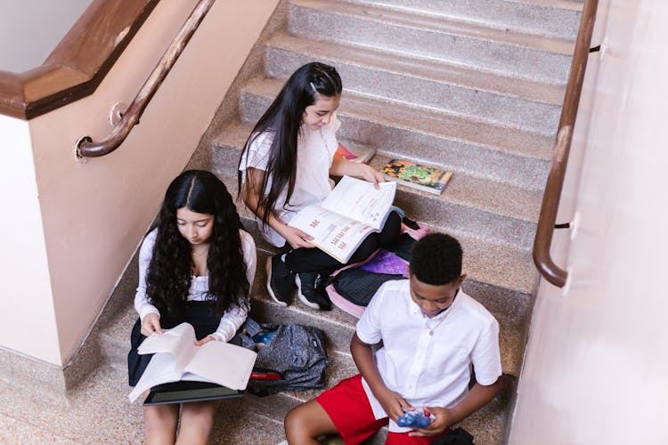 Students On The Stairs Reading Books