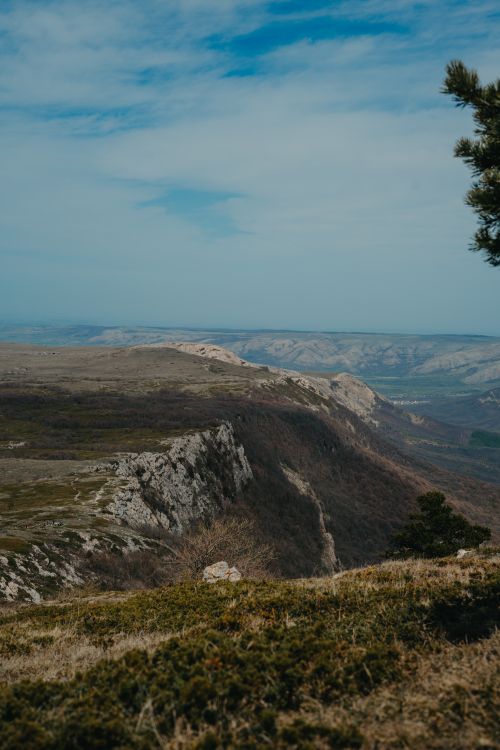Free A sweeping view of rugged mountains and valleys under a clear blue sky. Stock Photo