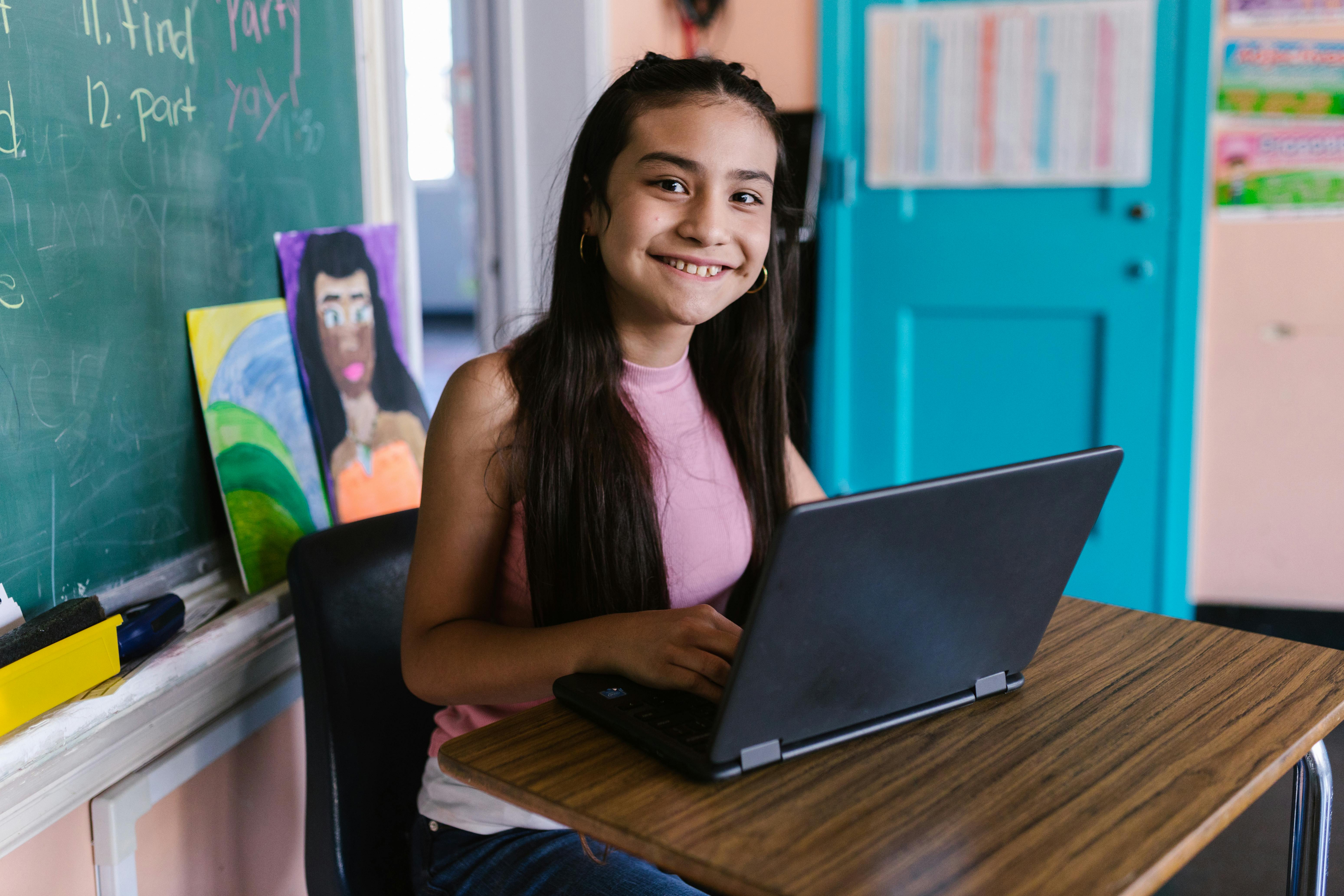 woman in pink sleeveless shirt using black laptop