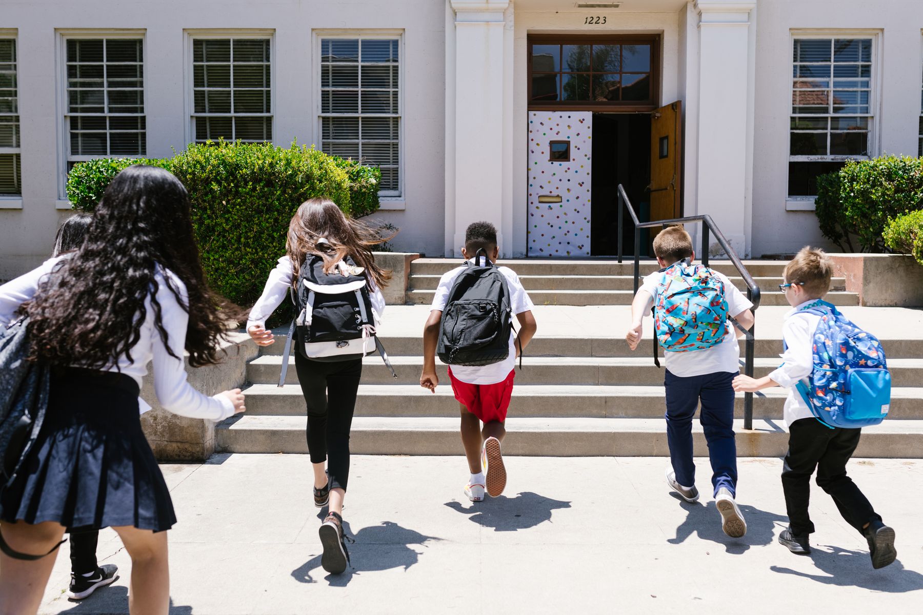 Children with backpacks arriving at school together
