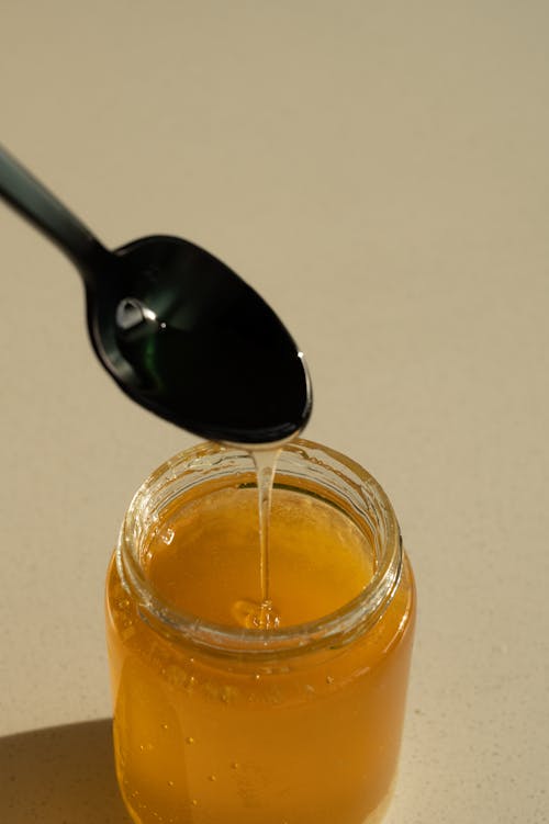 Free Spoon and a Jar Full of Honey  Stock Photo
