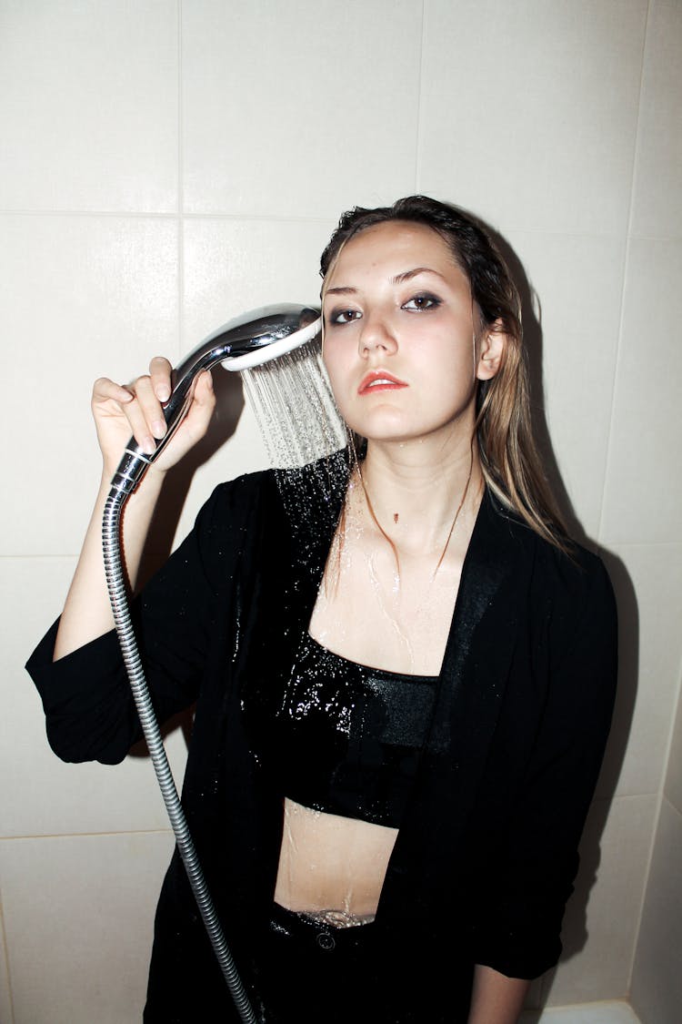 Woman In Black Blazer Holding A Handheld Shower Head 