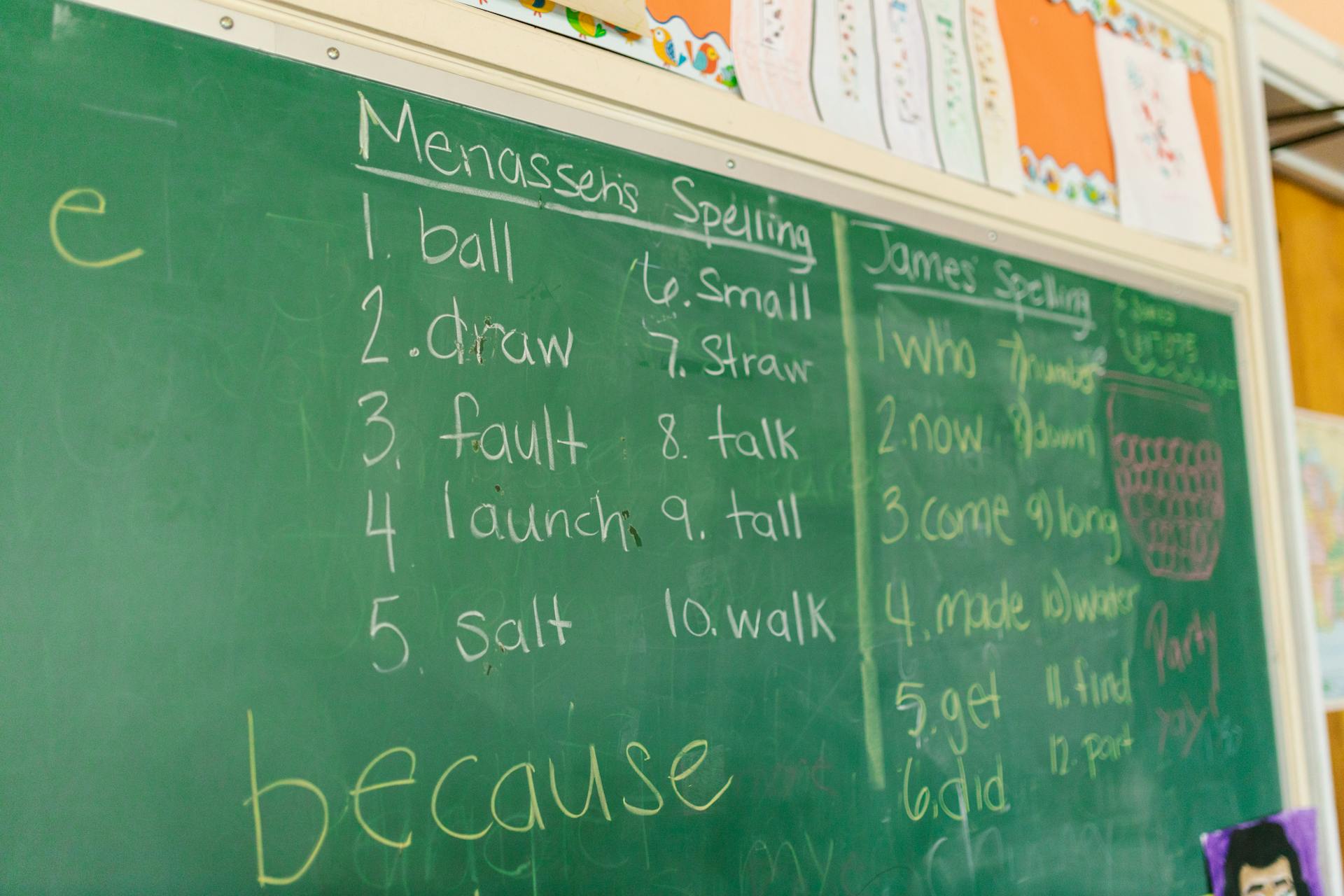 A classroom chalkboard featuring spelling lists and handwriting, ideal for education-themed content.