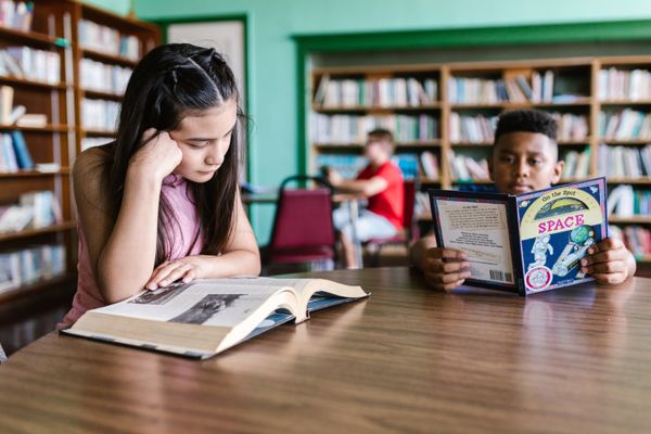 Children reading books inside the library