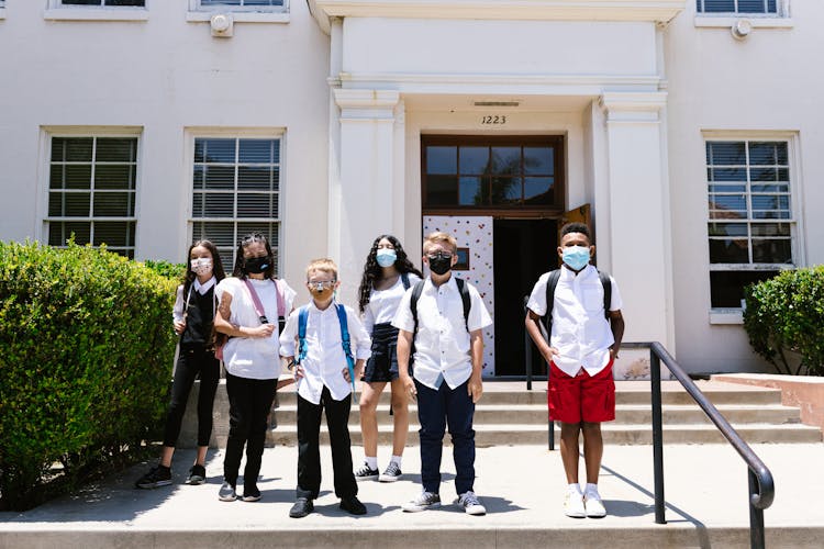 Children Wearing Masks In Front Of A School 