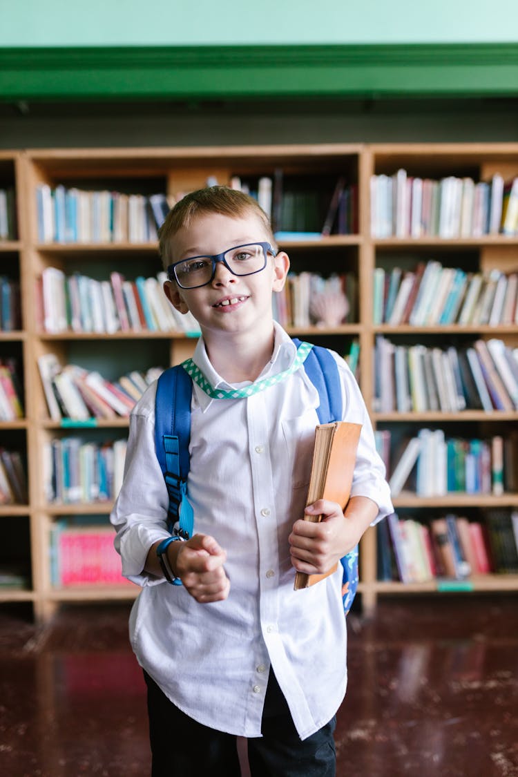 A Boy Wearing School Uniform Holding A Book