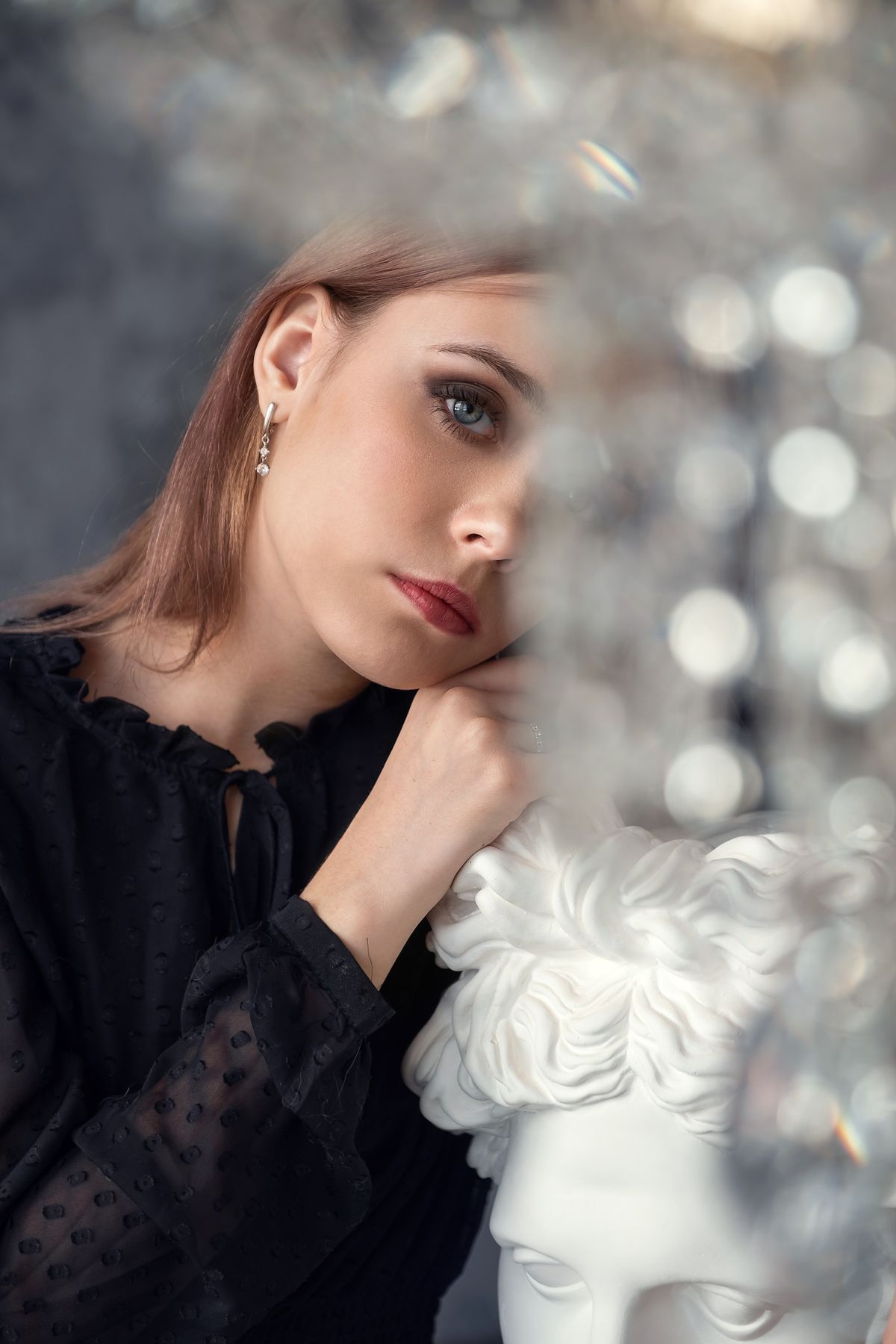 Editorial portrait of a woman beside white flowers