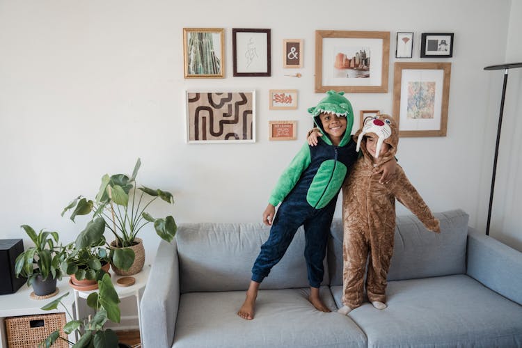 Children In Funny Pajamas Standing On Couch