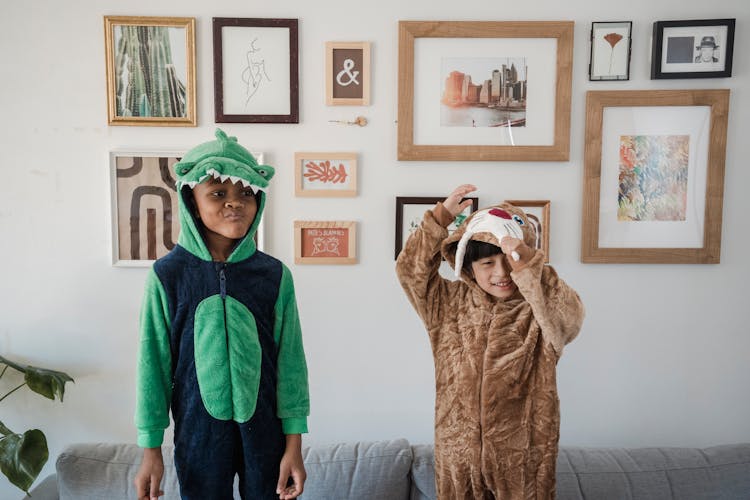 Kids Wearing Onesies Standing On The Couch