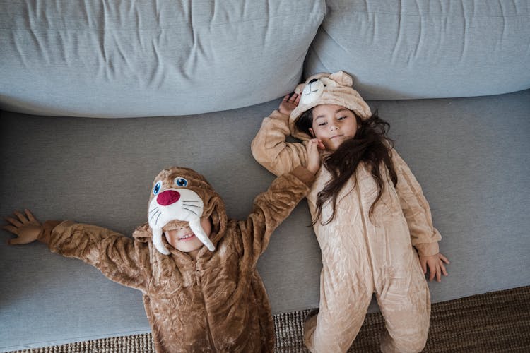 Kids On A Couch Wearing Onesies 