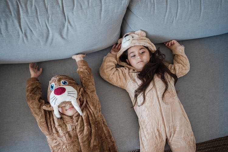 Kids On A Couch Wearing Onesies 