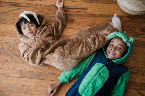 Free Boys in Animal Costumes Lying on the Floor and Smiling Stock Photo