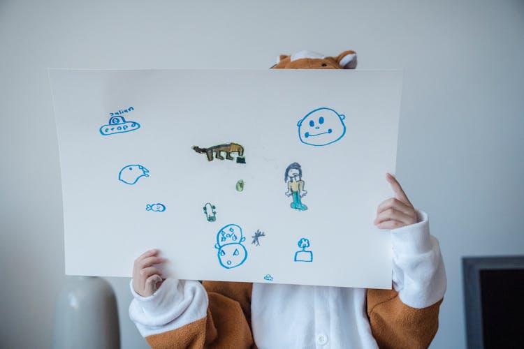 Kid Holding White Paper With Childish Drawings