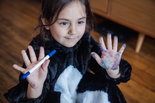 Free Girl in Black and White Pyjama Showing Dirty Hands After Drawing Stock Photo