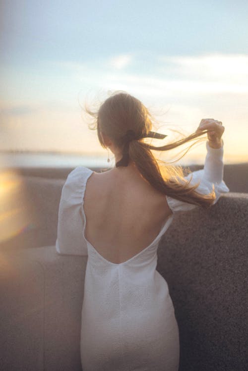 A Woman Wearing a Backless White Dress