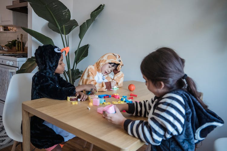 Photo Of Kids In Onesies Playing With Toys