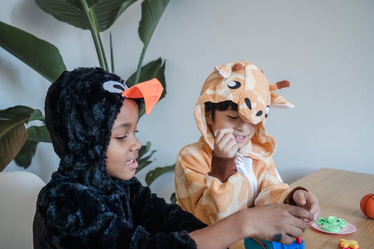 Photograph Of Kids In Onesies Playing With Toys